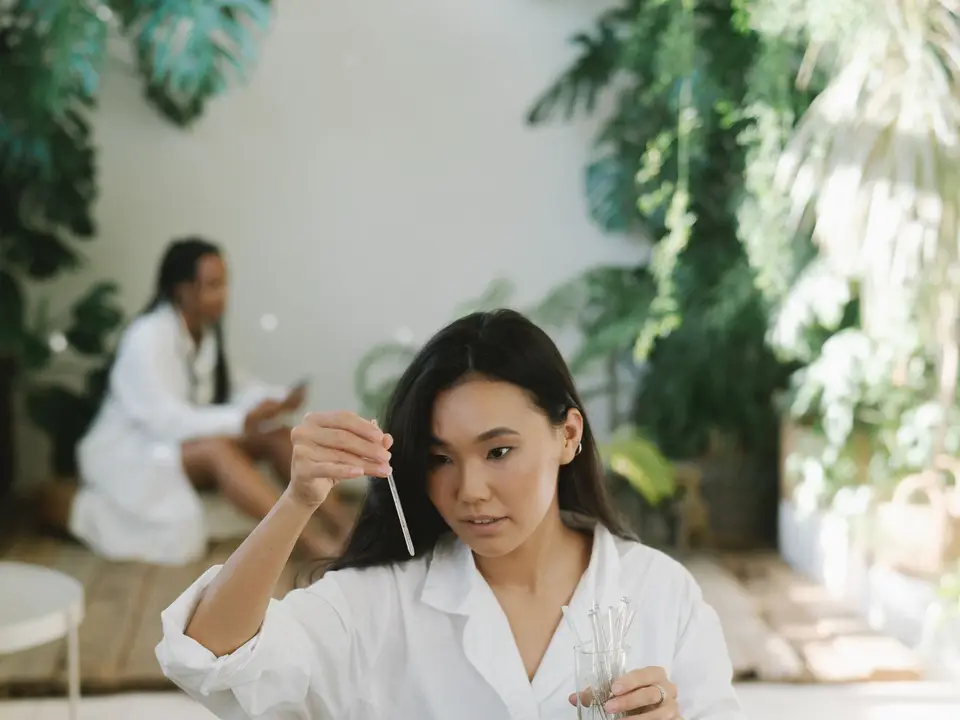 Gloved hand holding a water sample vial