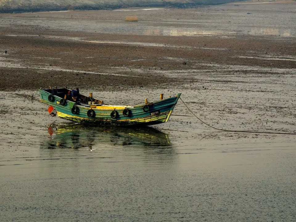 Small boat on a mudflat at low tide