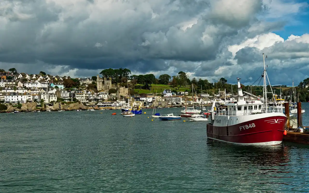 Cornish harbour with moored boats and hillside houses