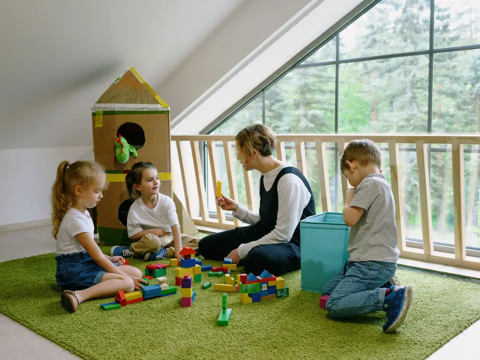 Children playing with blocks on a carpet