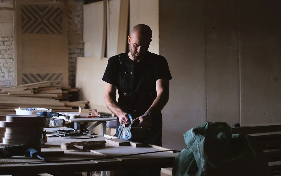A craftsman working with wood in a small workshop