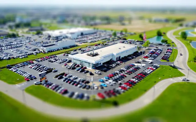 Row of generic sedans and SUVs on a dealership lot