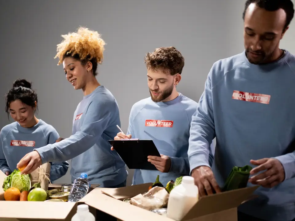 Team packing donated food into boxes on a long table
