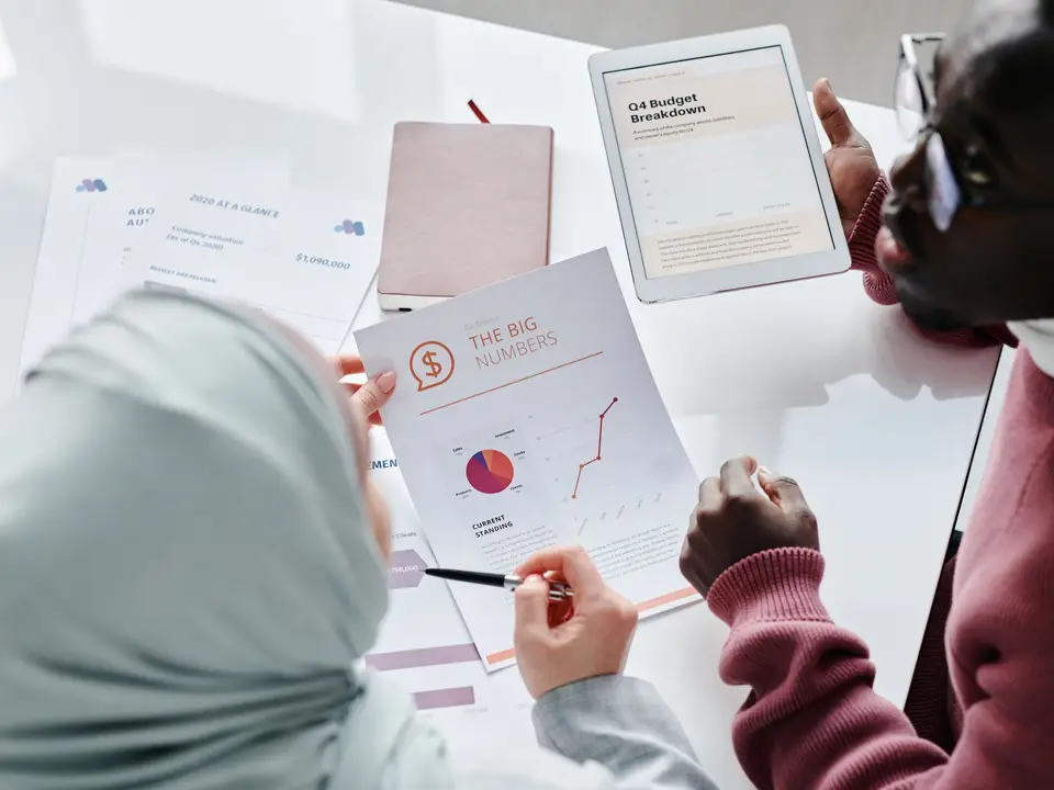 Team reviewing printed impact charts at a meeting table