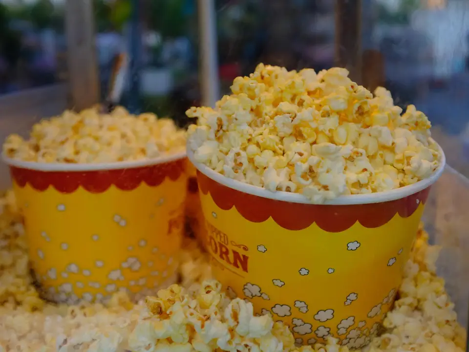 Two striped buckets of buttery popcorn at the cinema