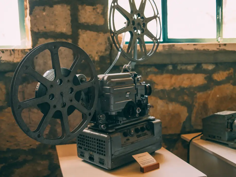 Vintage film projector with reels on a wooden desk