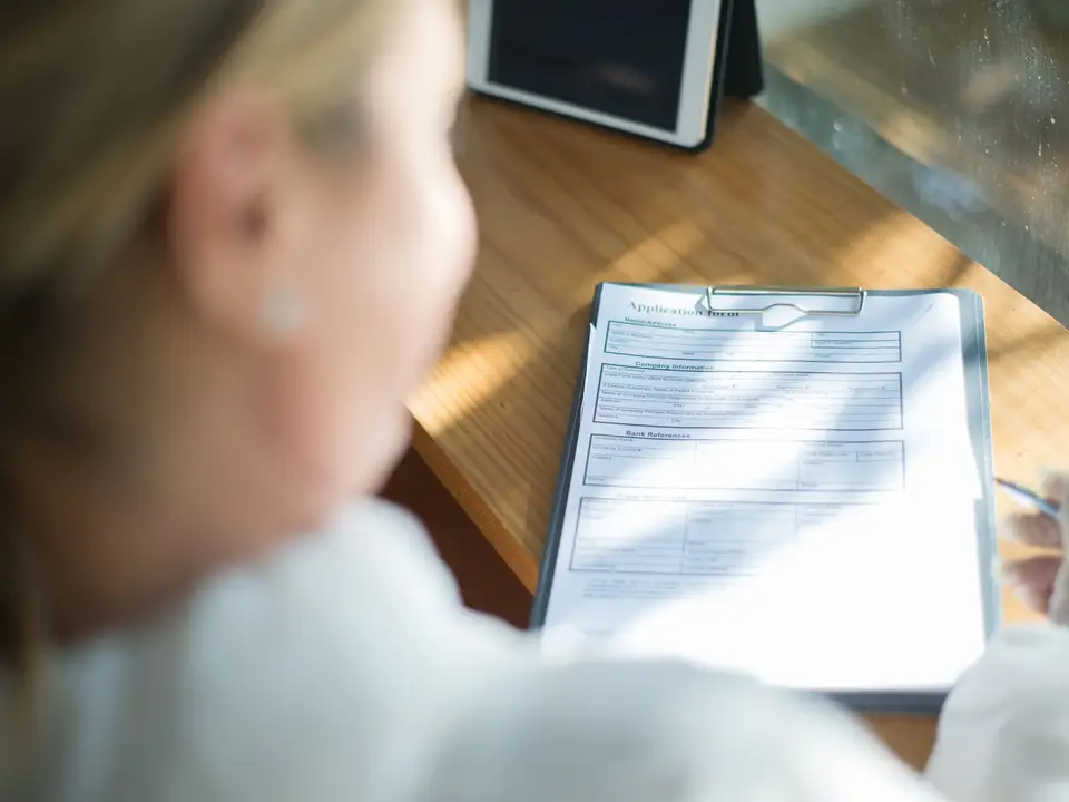 Woman filling in an application form on a clipboard