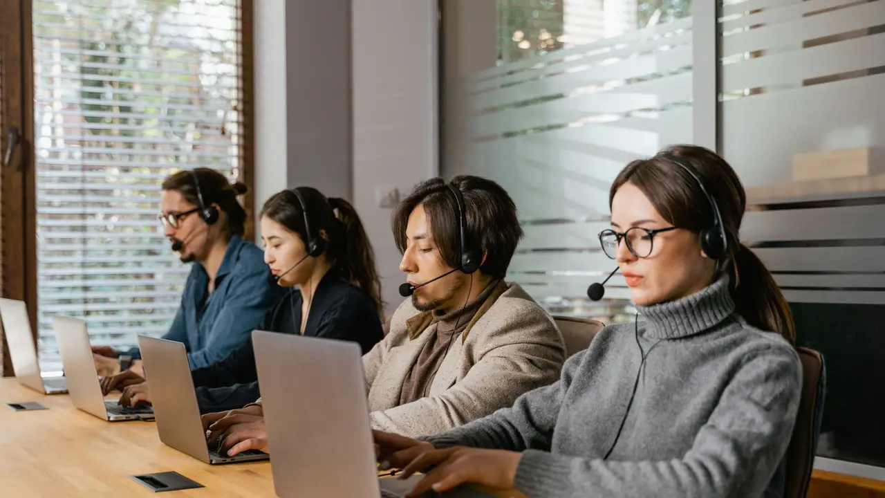 Support team with headsets at a long table