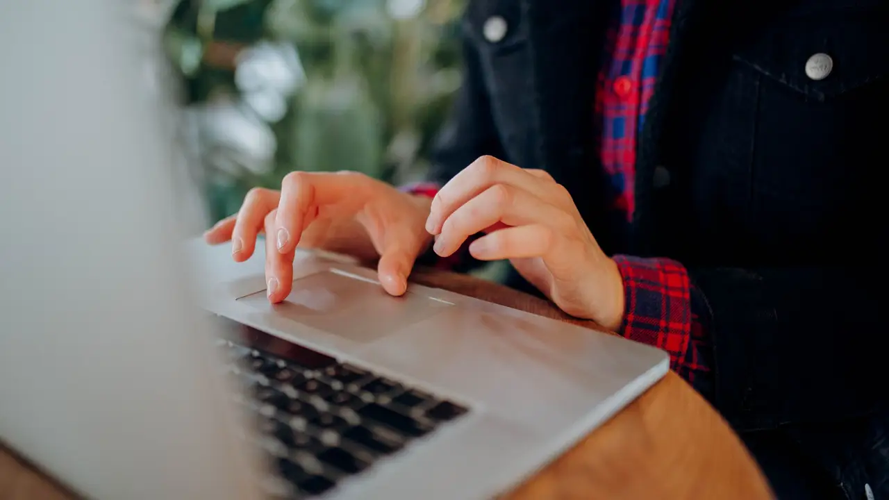 Hands typing on a laptop keyboard