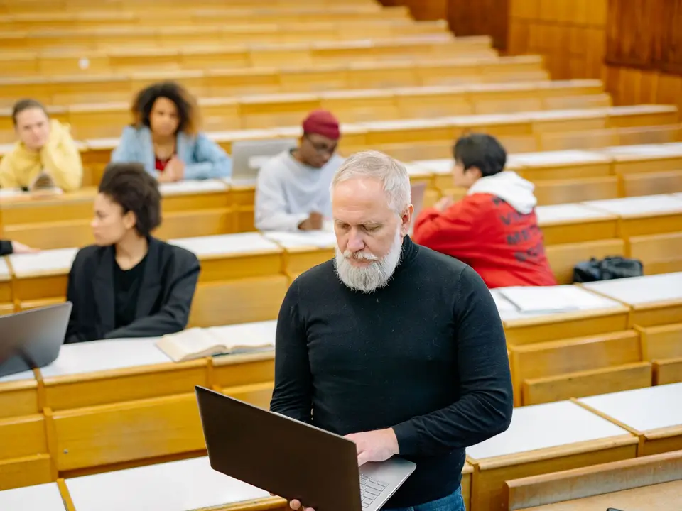 Teacher with students using laptops in a lecture hall