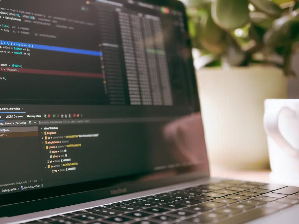 Laptop screen showing programming code and debugging tools