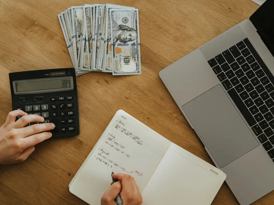Calculator, notebook and laptop on a wooden table planning finances
