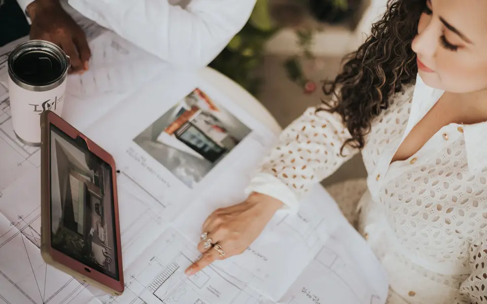 Brokers reviewing a floor plan on a conference table