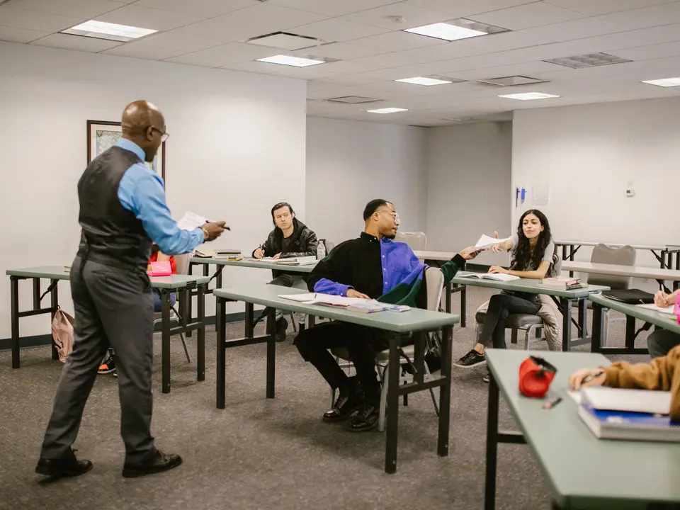 Adult learners listening to an instructor in a classroom