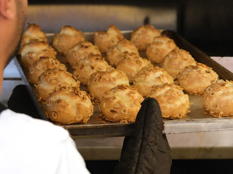 Baker lifting a tray of fresh pastries
