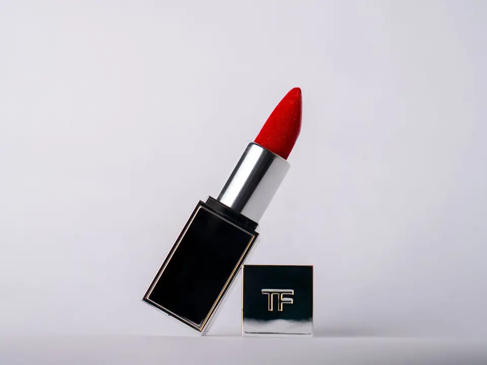 Red lipstick tube standing on a white surface