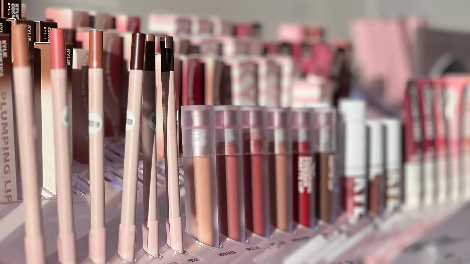 Sunlit cosmetics shelves with lipsticks and palettes