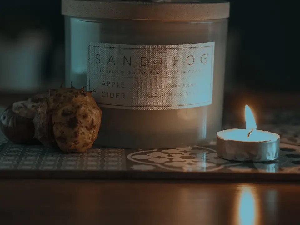 Hand twisting the lid of a glowing jar lantern