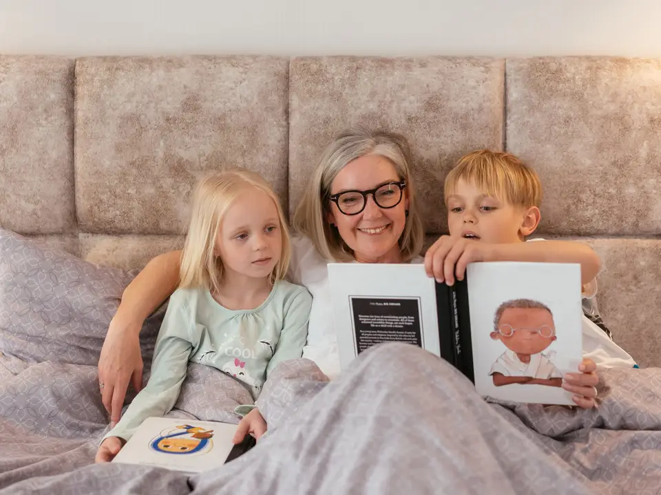 Grandmother reading a picture book with two young children