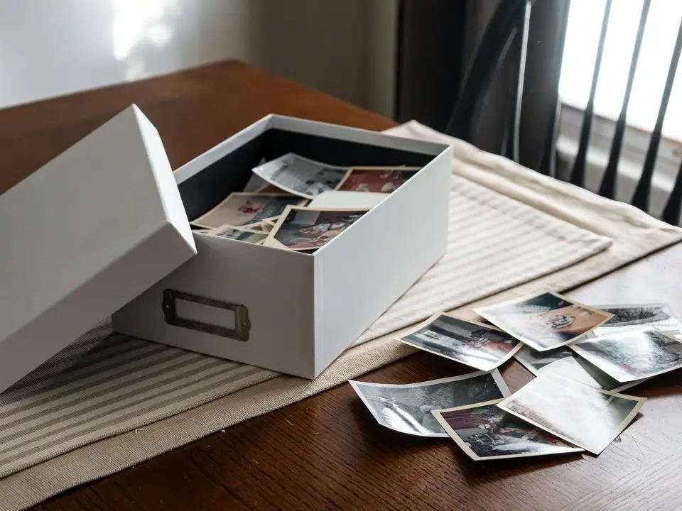 Open archive box filled with old printed photographs