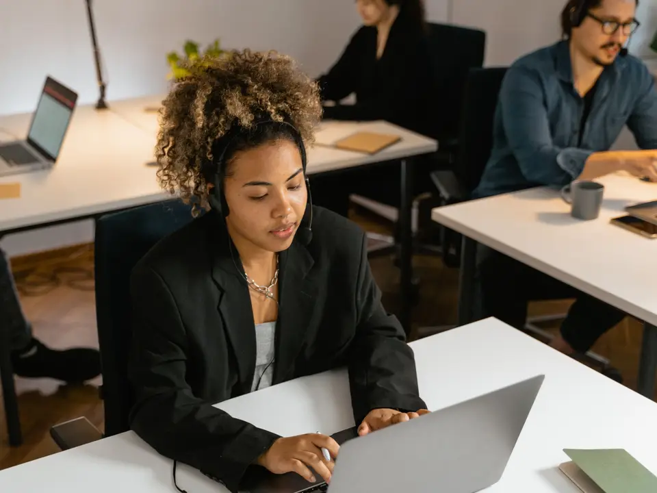 Support representative working at a laptop in a modern office
