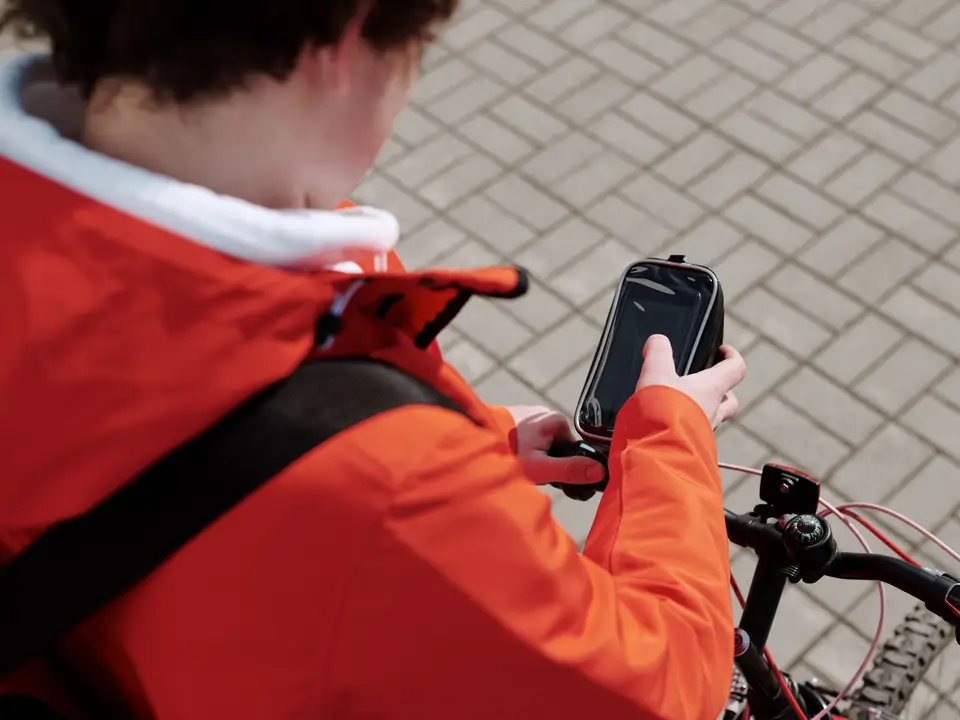 Cyclist checking phone with bike
