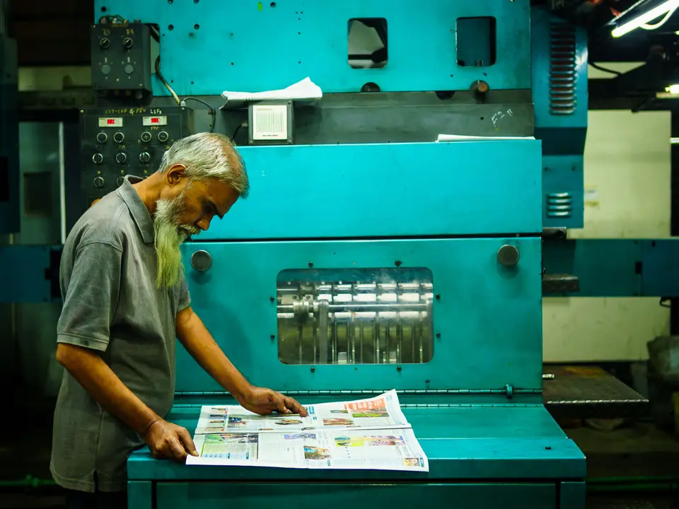 Printer checking a sheet at the press