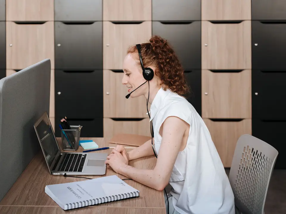 Support representative wearing a headset working at a laptop