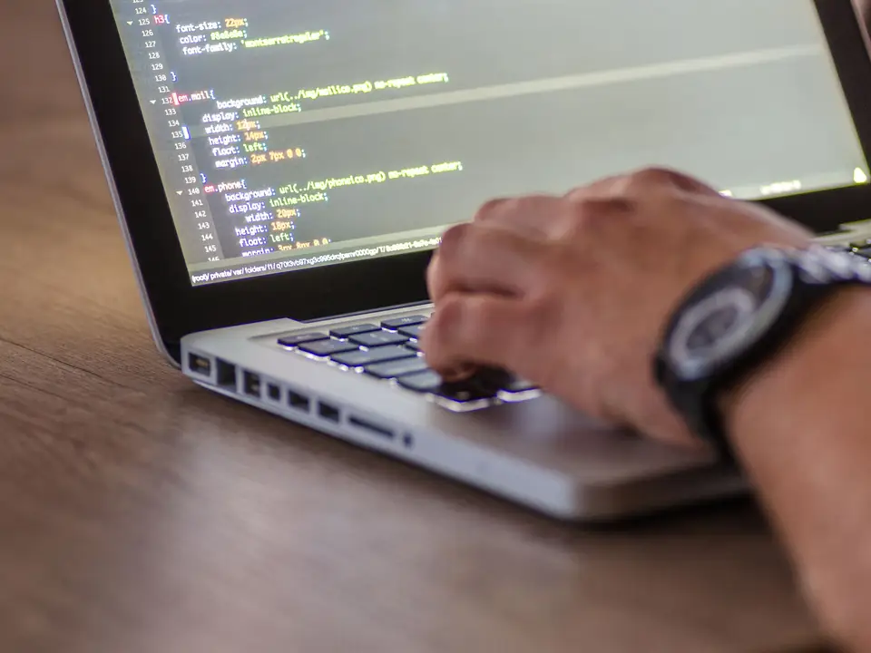 Close-up of a person coding on a laptop