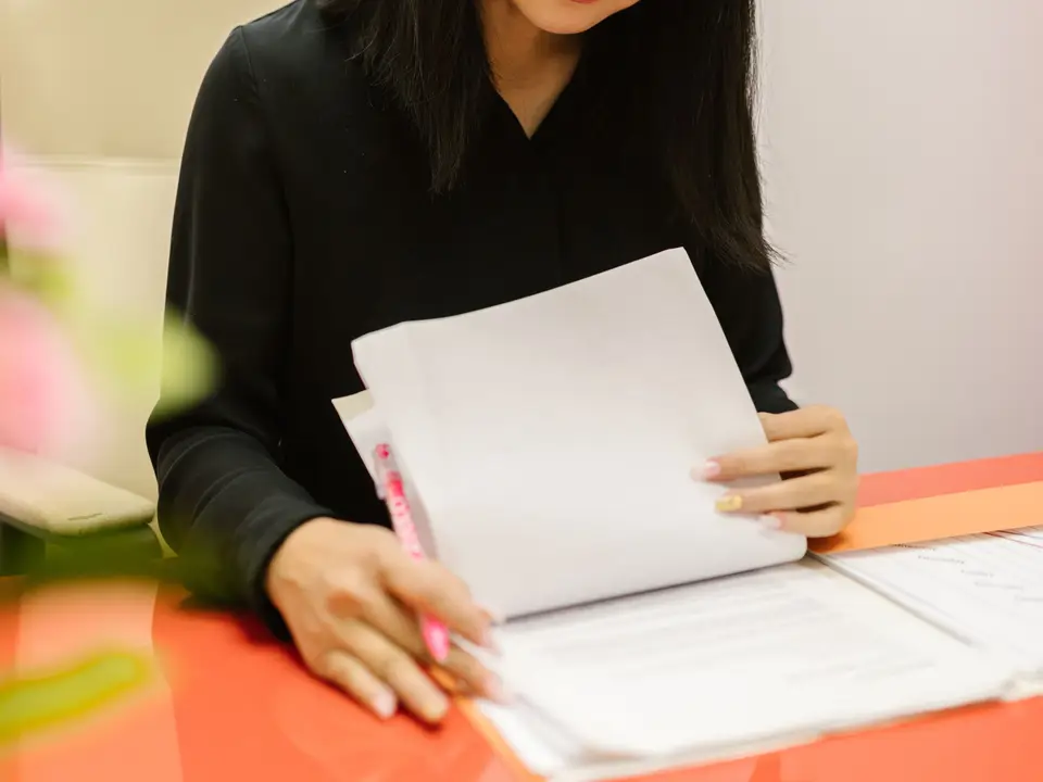Woman reading papers at a modern office desk