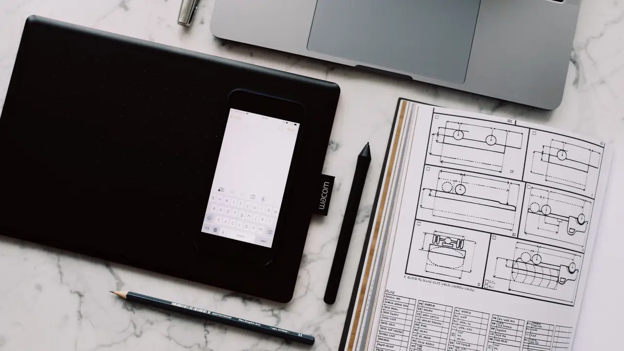 Designer editing vector icons on a widescreen monitor