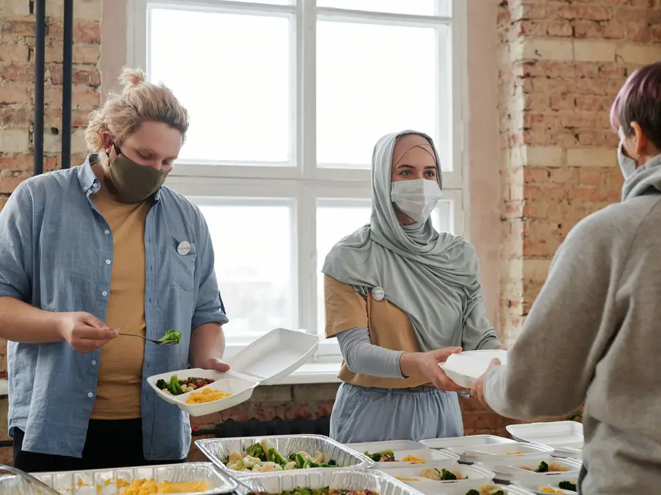 Volunteers serving hot meals to residents