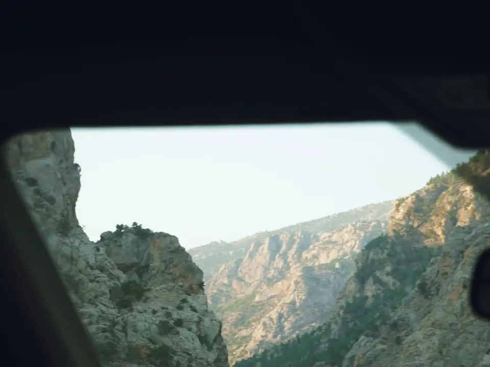 Driving through a rocky mountain canyon at sunset