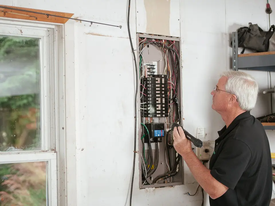 Wall-mounted EV charger beside a garage door