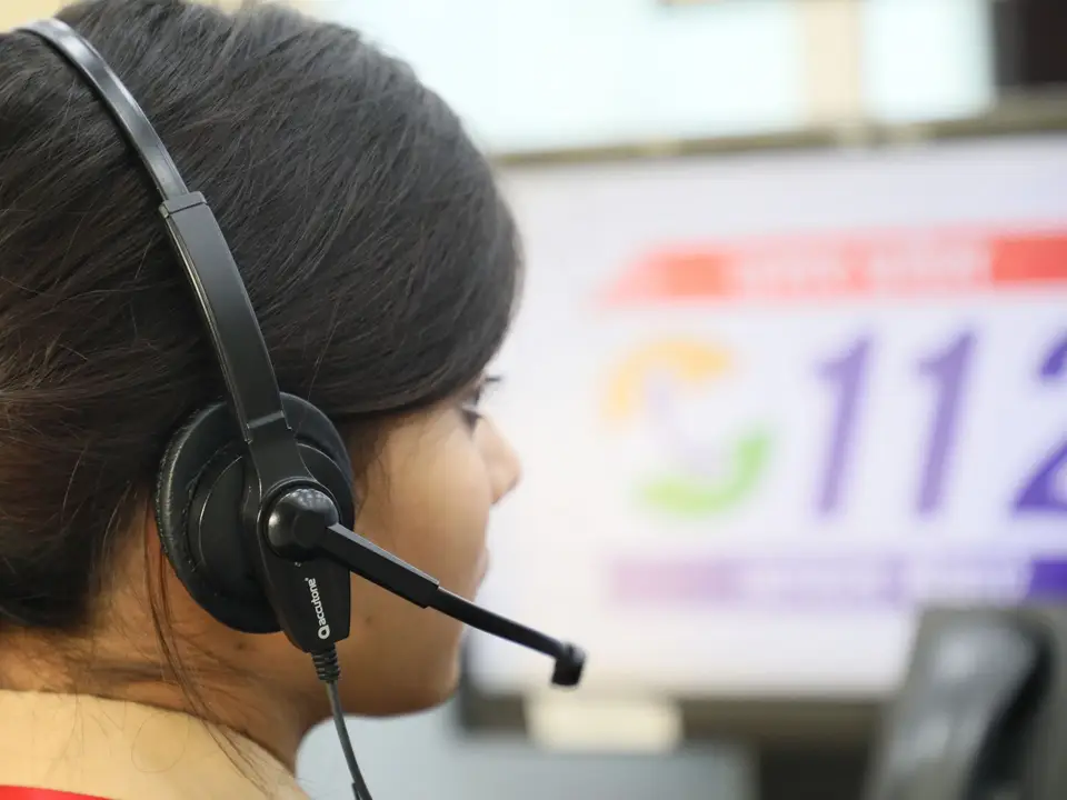Emergency dispatcher wearing a headset at a console