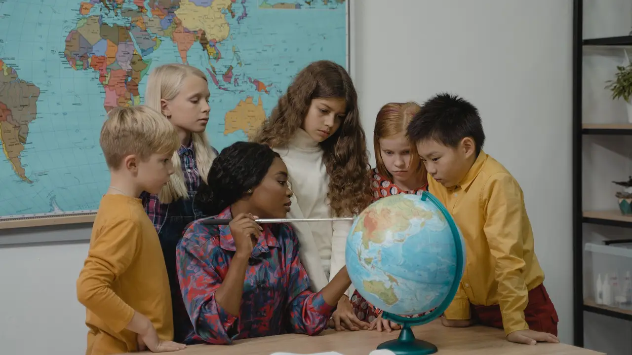 Students gathered around a map and globe in class