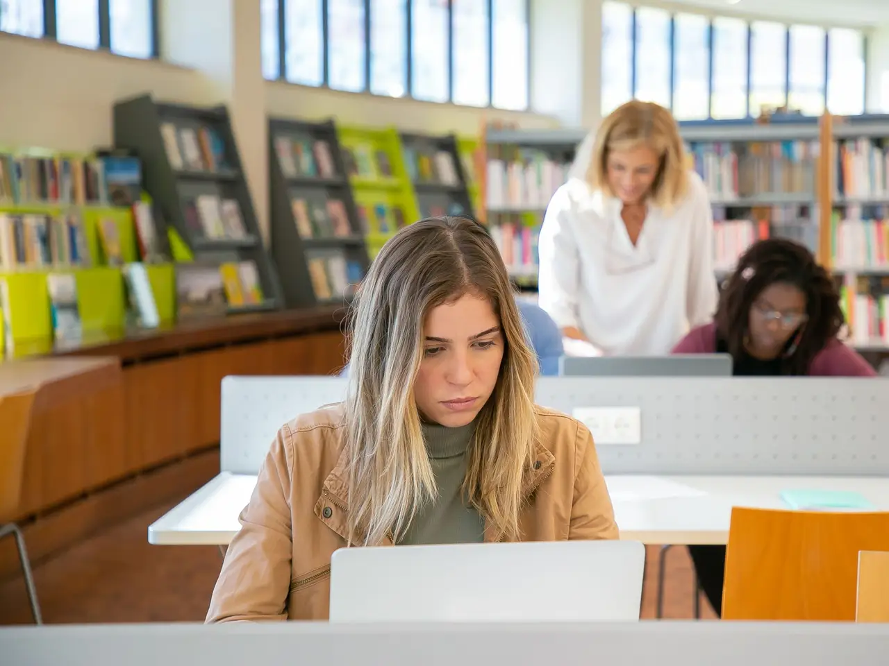 Students working on laptops in a modern library