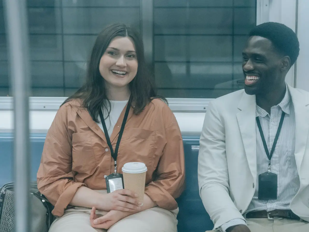 Colleagues smiling together on a commuter train