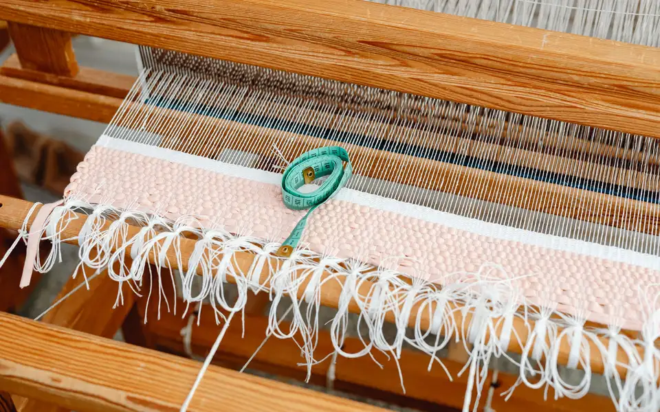 Close-up of hands stitching fine wool fabric