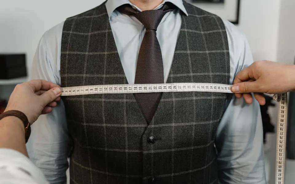 Stylist pinning a jacket during a fitting