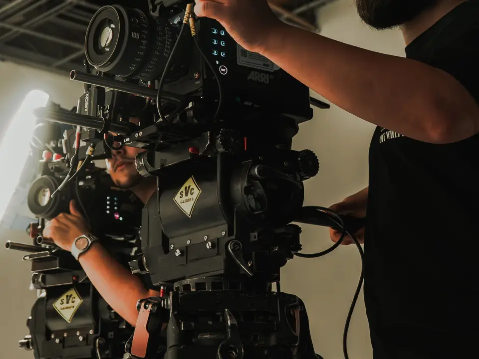 Camera operator working an ARRI cinema camera on a studio set