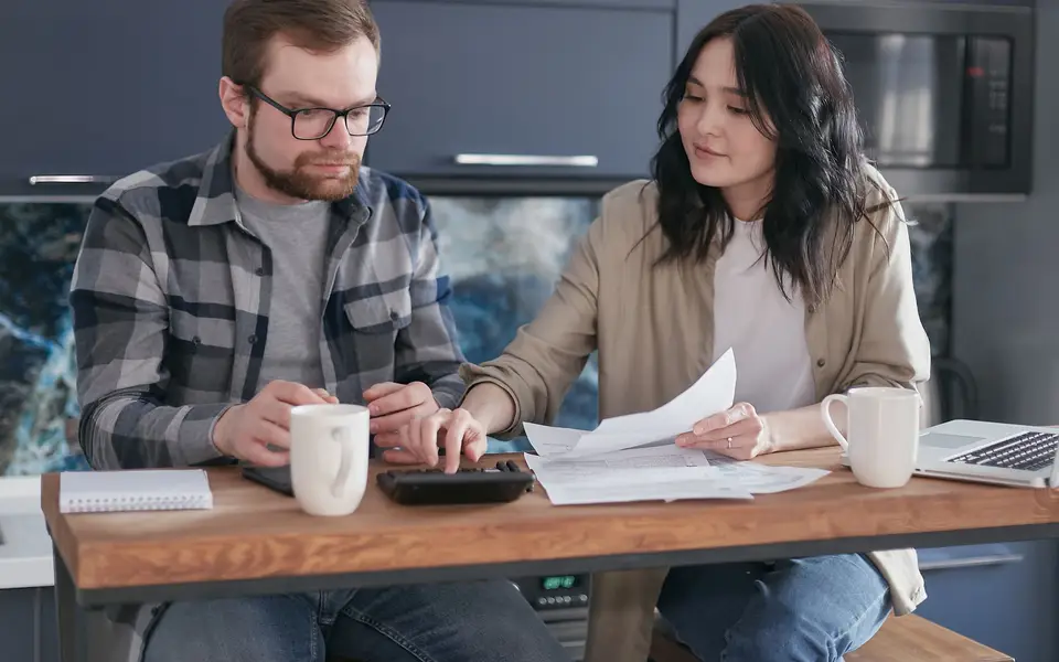 A couple sorting statements and a calculator at their table