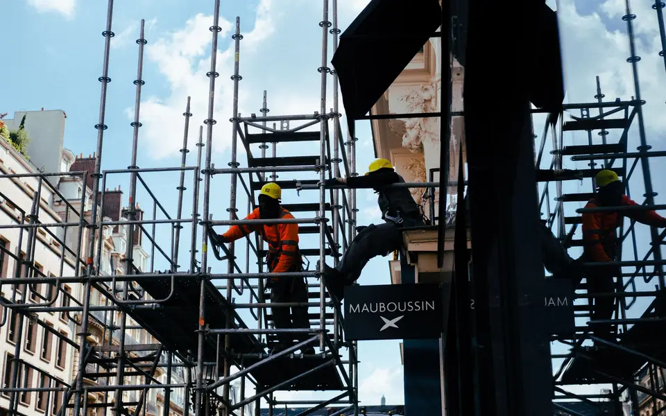 Construction workers resting in shade on scaffolding
