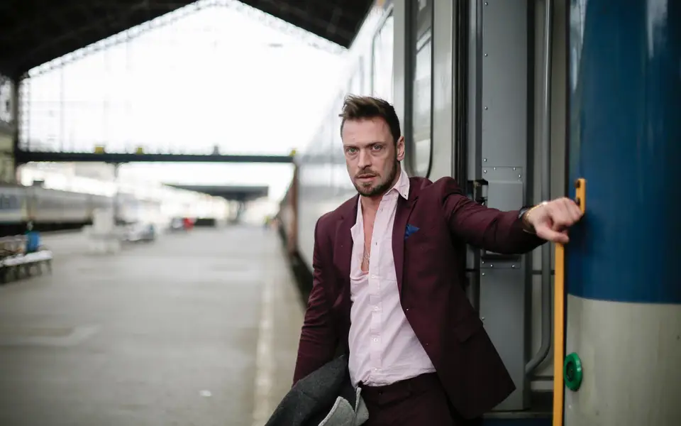 Commuter stepping off a train with leather satchel