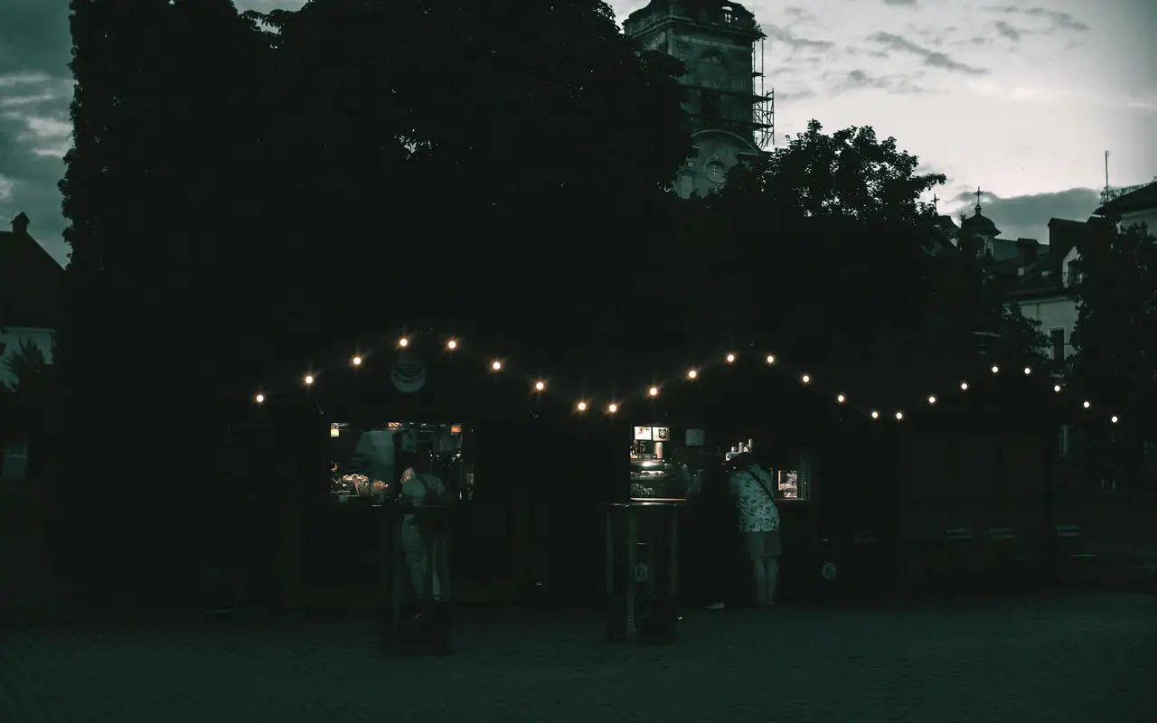 Market stalls lit by single bulbs after midnight