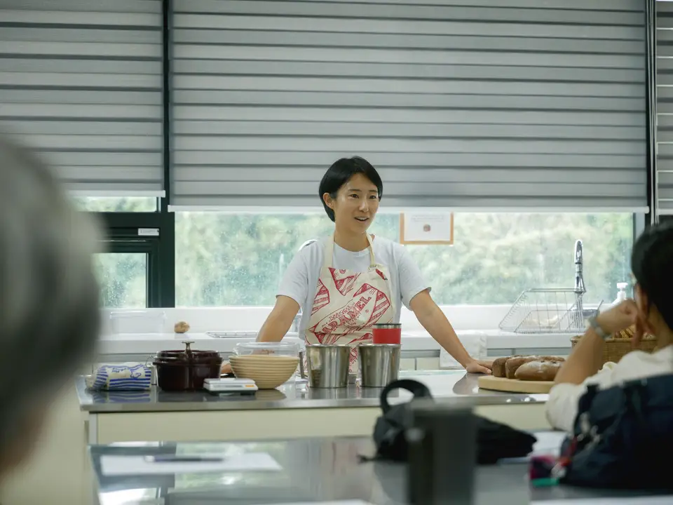 Chef leading a cooking class, explaining techniques to students in a bright, modern kitchen