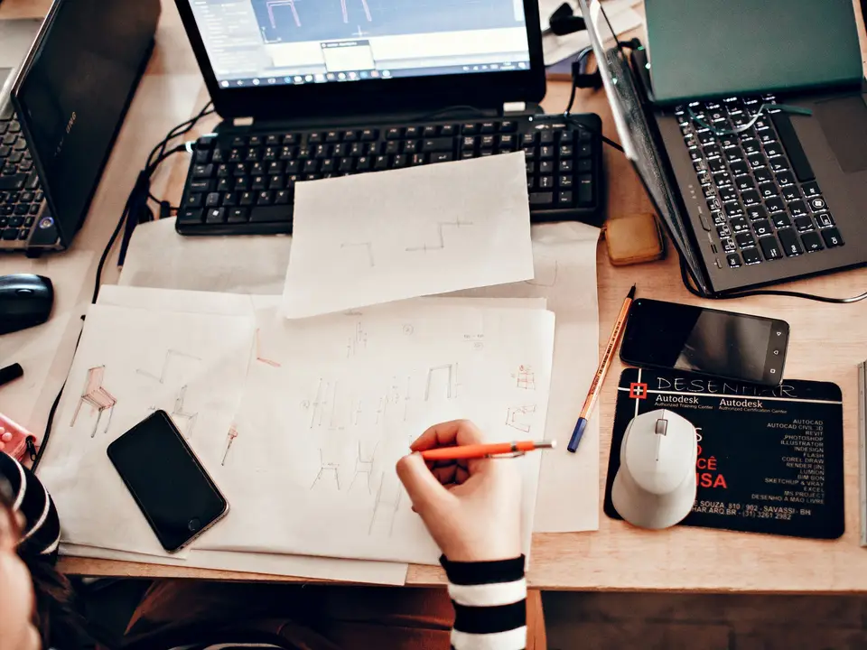 Designer sketching furniture dimensions at a drafting table