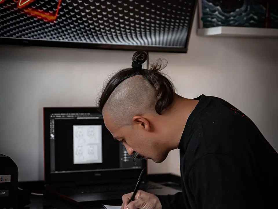 Digital artist working at a desk with design software in a creative studio