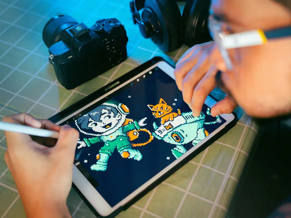 Colourful character illustration being drawn on a tablet with a stylus