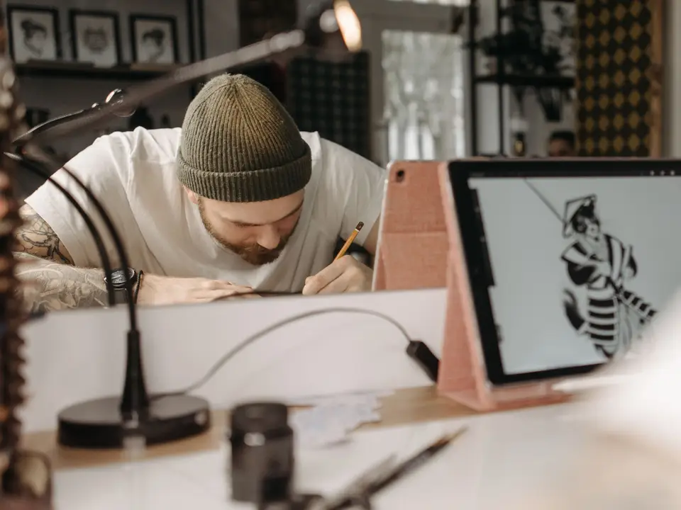 Artist drawing a detailed black and white character on a tablet